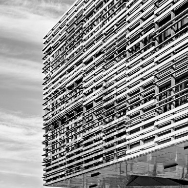 Black and white photo of the “Sculpture Wall” cladding system. The cost-effective, thermally broken, high-performance envelope is enhanced by a custom louvre system that unifies the upper levels as an attractive singular, sculptural volume – choreographing views to campus and distant mountains while maximizing useful natural light. Photo by Andrew Latreille.