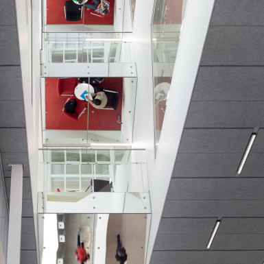 View upward through atrium from the ground floor, showing study pods with reflective soffits and fascia. Photo by Andrew Latreille.