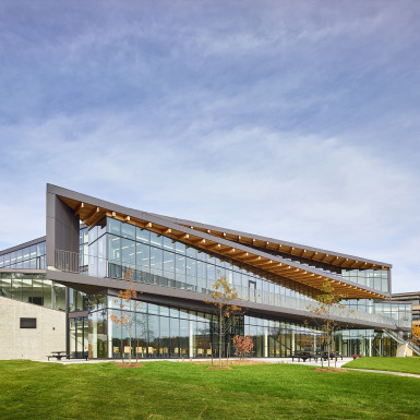 View of river-facing façade looking north with overhangs providing shading and outdoor terrace at the second floor level. Photo by Scott Norsworthy.