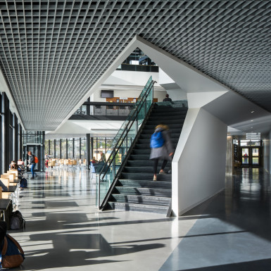 View of into the central forum of the student centre, with highlighting the feature stair, and throughway pedestrian connection that extends through the building. Photo by Andrew Latreille.